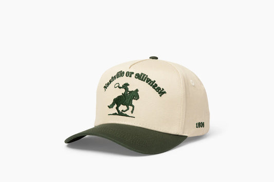 Front 3/4 view of a cream and dark green baseball cap with "Nashville or Nashville" text arcing over an embroidered cowboy on a horse logo, plus "1806" on the side.