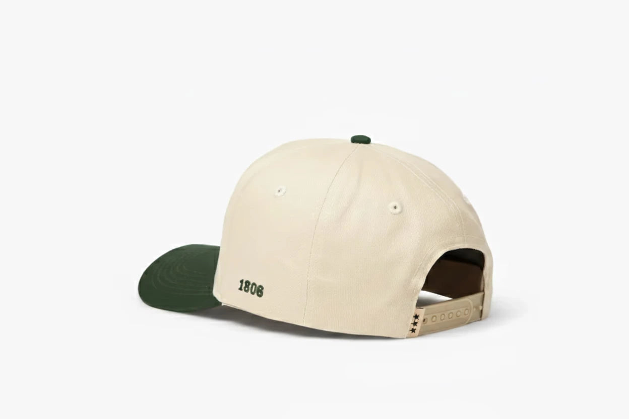 Beige baseball cap with dark green brim, featuring "1806" embroidered on the back and three black star details on the adjustable strap. Back view.