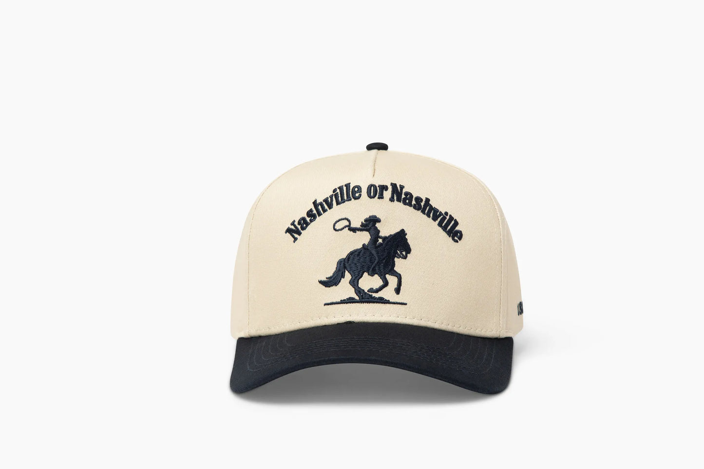 Front view of a beige baseball cap with a prominent dark blue brim, showcasing "Nashville or Nashville" embroidered above a cowgirl riding a horse graphic.